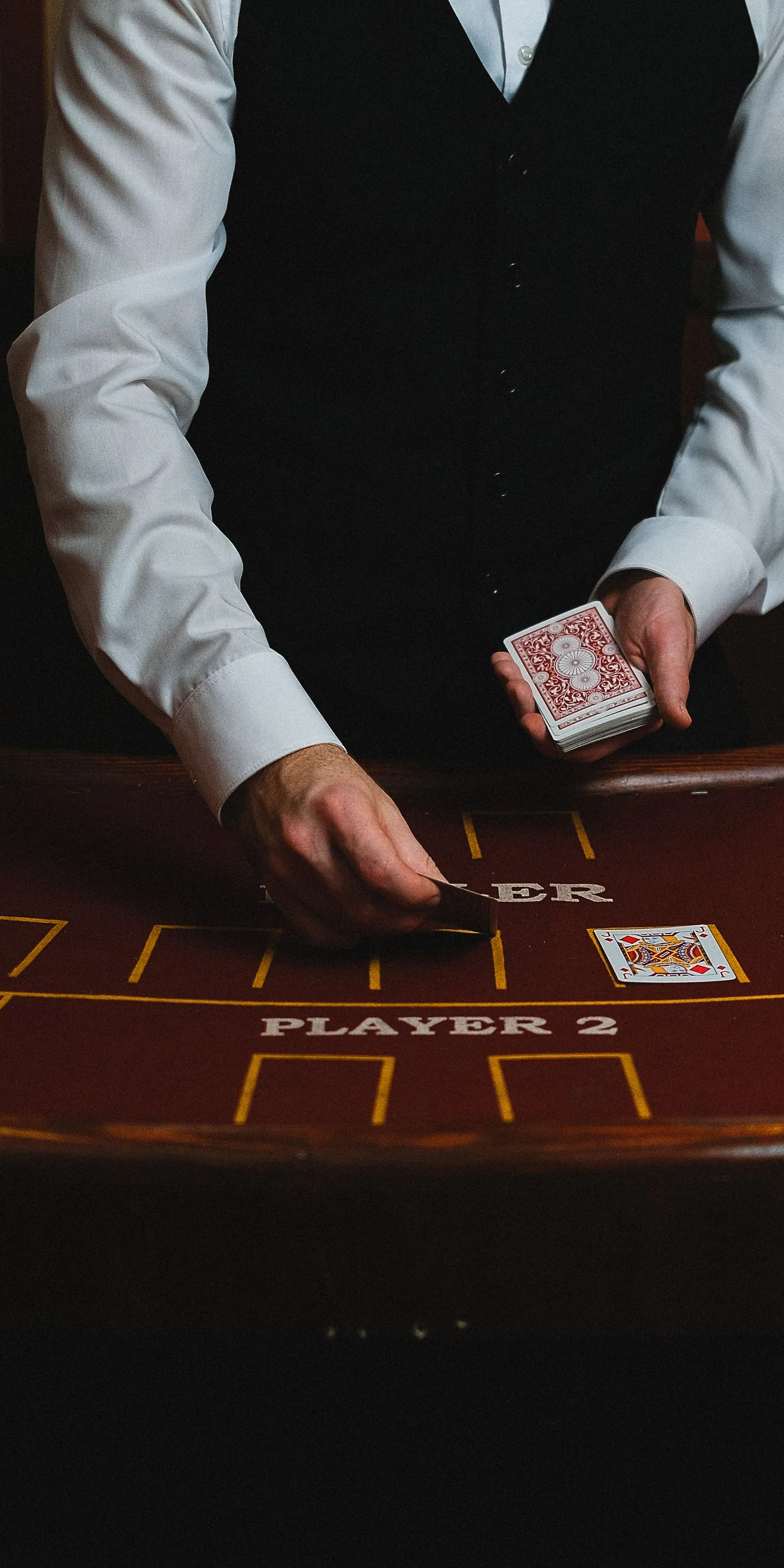 Casino dealer handling cards at a table