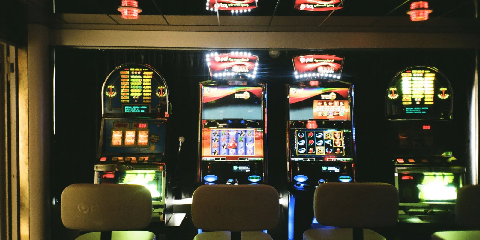 Empty row of illuminated slot machines inside a casino