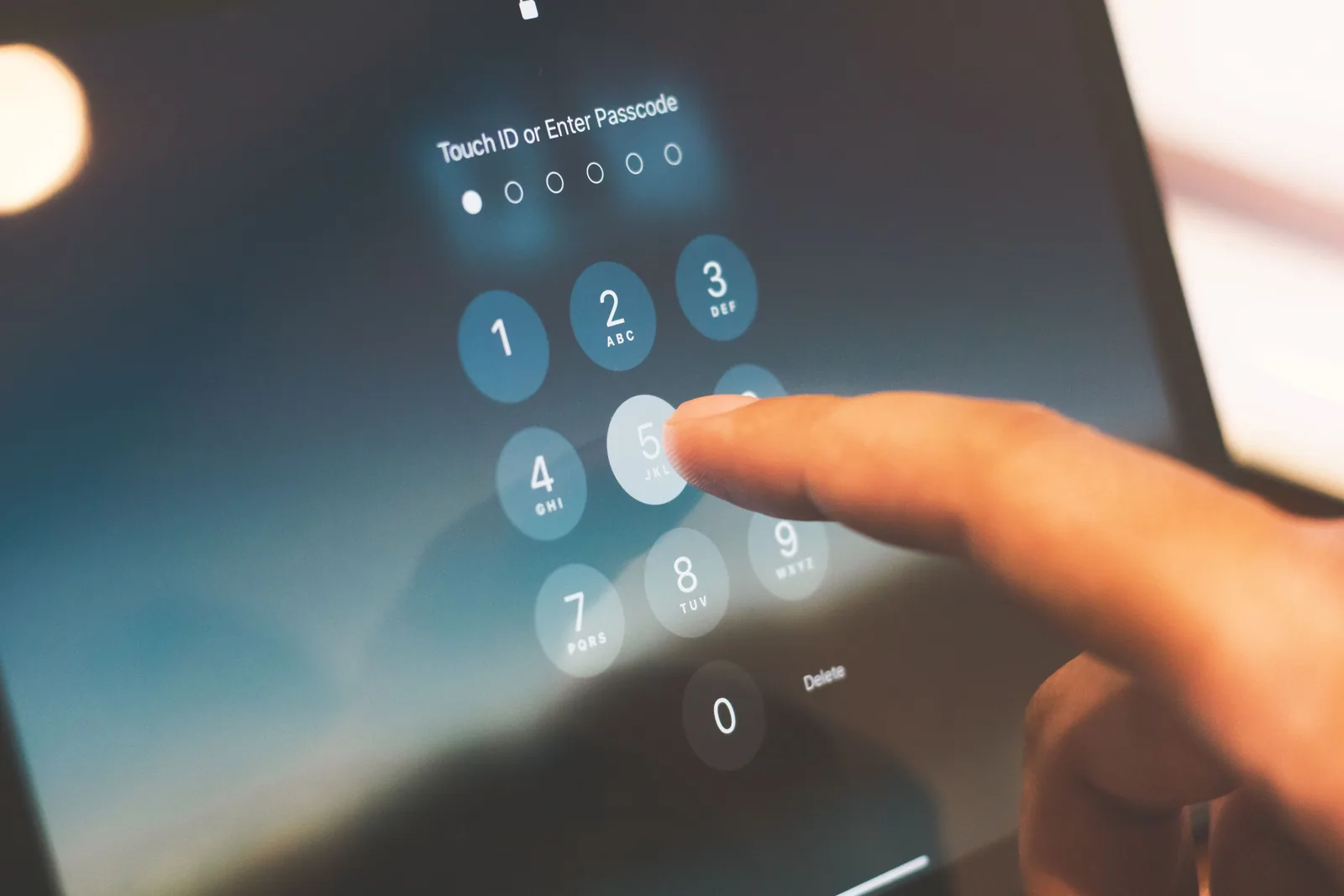 Finger entering a passcode on a mobile device